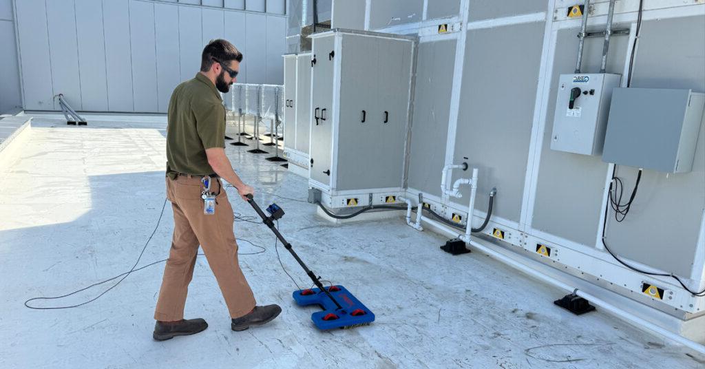 Quality Coordinator Grant Foreman operates the IntegriScan Electronic Leak Detection system on the roof of Miller Electric Center, the Jacksonville Jaguars practice facility and sports performance center.